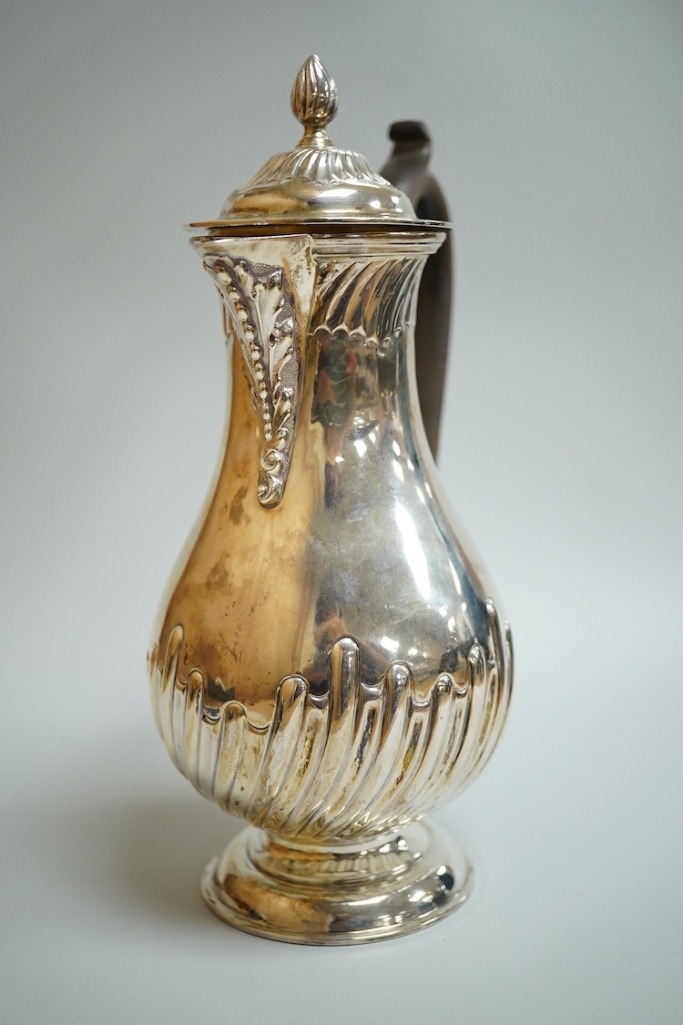 An Edwardian demi-fluted silver baluster hot water jug, William Hutton & Sons, London, 1902, height 21cm, 13.4oz.